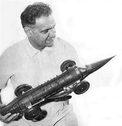 Dr. Nathan Ostich holding a model of the Flying Caduceus circa 1960