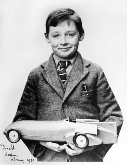 Donald, son of Malcom Campbell, holding a Kingsbury tin toy model of his father’s 1928 Bluebird LSR car.