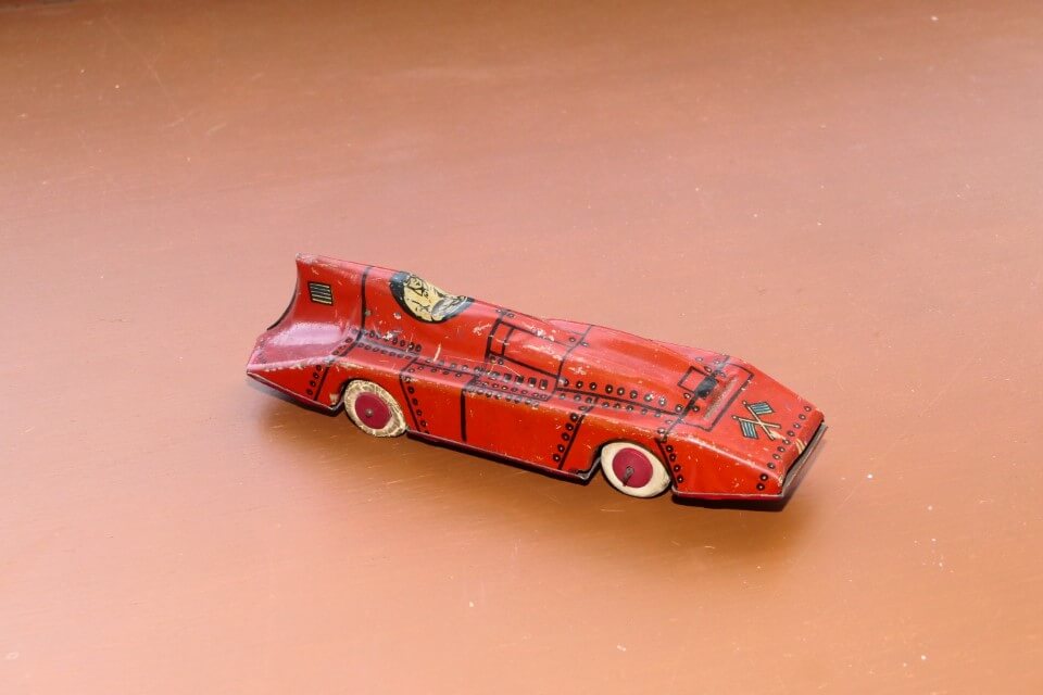 USA. Lindstrom Tin clockwork. Marked “Lindstrom made in USA” Wooden wheels, rubber tyres. Sold in at least 8 different colours, with and without clockwork motor. 150mm