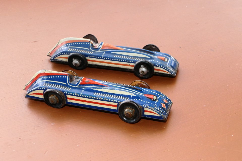 Japan ? Unknown Maker Tin. Marked “Foreign” Tin-wheels/tyres. The one in front with crossed flags has no base plate. 130mm